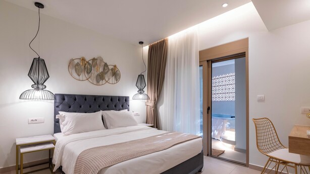 Ein modernes Schlafzimmer mit einem großen Bett, Nachttischen, einem Schreibtisch mit Stuhl und einem Balkon mit Blick.