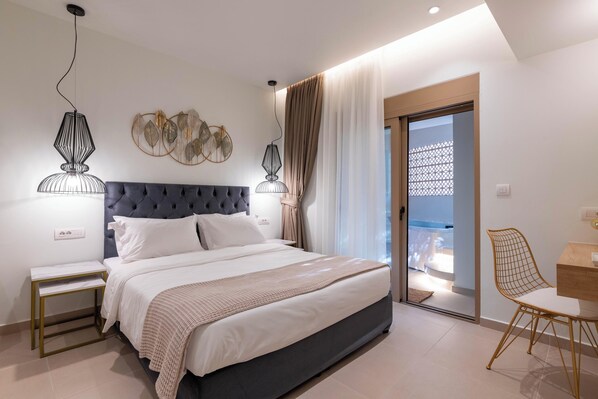 A modern bedroom with a large bed, bedside tables, a desk with a chair, and a balcony with a view.
