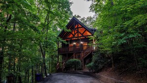 Une cabane dotée d’une terrasse en bois et d’un escalier menant à un deuxième niveau.