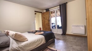 A bedroom with a bed, a radiator, and a sliding glass door leading to a balcony.