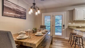 A dining area with a wooden table set for four, a bench, and two bar stools. - Tranquility Hollow Private INDOOR POOL, WIFI, next to Dollywood (Sevierville)