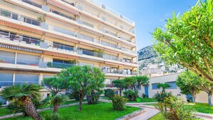 Un hôtel à plusieurs étages doté de balcons, d’un jardin bien entretenu et offrant une vue sur un paysage montagneux.