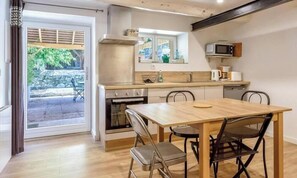 A compact kitchen with a dining area, a microwave, and a view of the outdoor area.