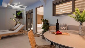 Un interior moderno con zona de estar, mesa de comedor y ventanas amplias.