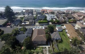 An aerial view of a coastal residential area with houses, a street, and a beach in the background. - STEPS TO OCEAN, NEW,CLEAN #2 (Oceanside)