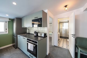 A compact kitchen with a built-in oven, a coffee maker, and a toaster.