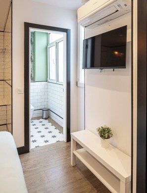 Une salle de bain comprenant des toilettes, une poubelle, un lavabo et un espace douche.