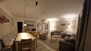 Amplia sala de estar con mesa de comedor, sofá y una pequeña mesa de centro.