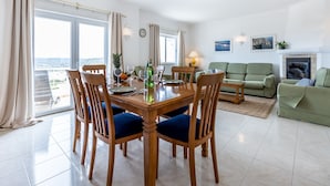 Un espacio habitable amplio con una mesa de comedor, sillas, un sofá y una chimenea.