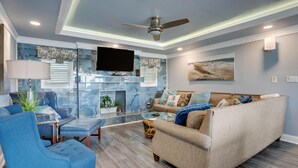 A modern living room with a fireplace, a television, and a comfortable seating area.