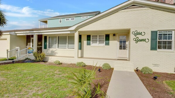A two-story building with a covered porch and a sign indicating it is a North Beach Vacation rental. - Oceanfront Private Beach House w/Private Hot Tub + Free Attraction Tickets! (Atlantic Beach)