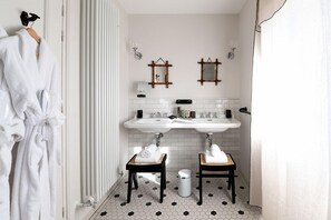 Une salle de bain avec deux lavabos, un miroir et un porte-serviettes.