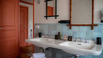 Un bagno con due lavandini, uno specchio e articoli da toilette sul piano di lavoro.