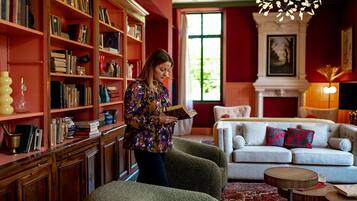 A cozy living room with a fireplace, a bookshelf filled with books, and a comfortable sofa with decorative pillows.