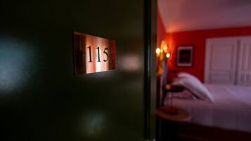 Habitación de hotel con una puerta que indica el número 115.