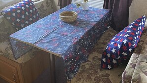 A compact RV interior with a dining table, bench seating, and a small cabinet.