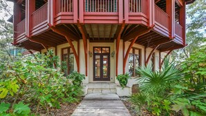 Una casa in legno con un balcone, una porta d'ingresso e un vialetto che conduce all'entrata.