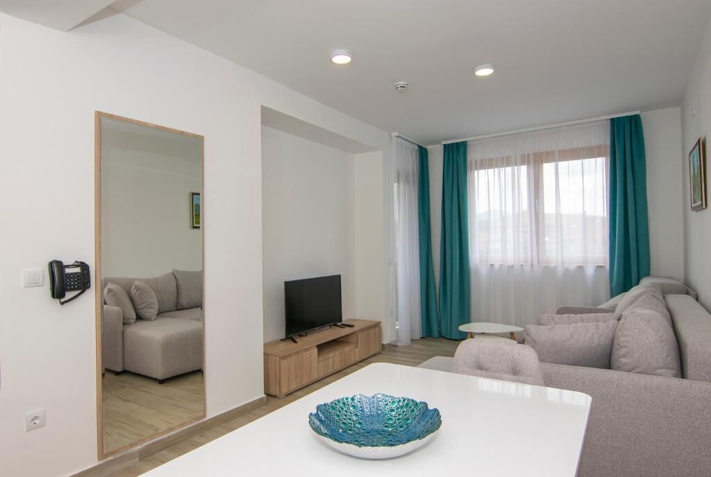 A modern living room with a sofa set, a television, and a decorative bowl on a table.