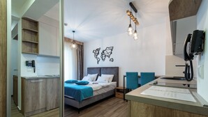 Een moderne hotelkamer met een bed, een bureau, een telefoon en een kaart aan de muur.