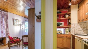 A kitchen with wooden cabinets, a microwave, and a sink.
