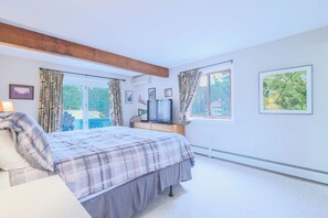 A bedroom with a bed, a television, and a window with curtains. - Official Seasons RMC Condo 11D - 2 Bedroom  - sleeps 6 - Dog Fees (Bartlett)
