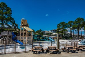 A water park with multiple slides and picnic tables.