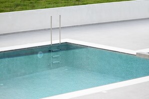 A rectangular swimming pool with a ladder, surrounded by a white tiled deck. - Smaragdi Kos Hotel (Kos)