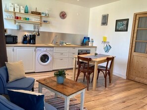 A compact living space with a kitchenette, a dining area, and a sofa.