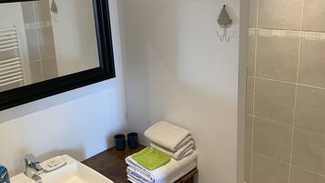 Bathtub, hair dryer, towels, toilet paper