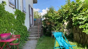 Un sendero estrecho que conduce a una casa con un pequeño espacio al aire libre y un tobogán.