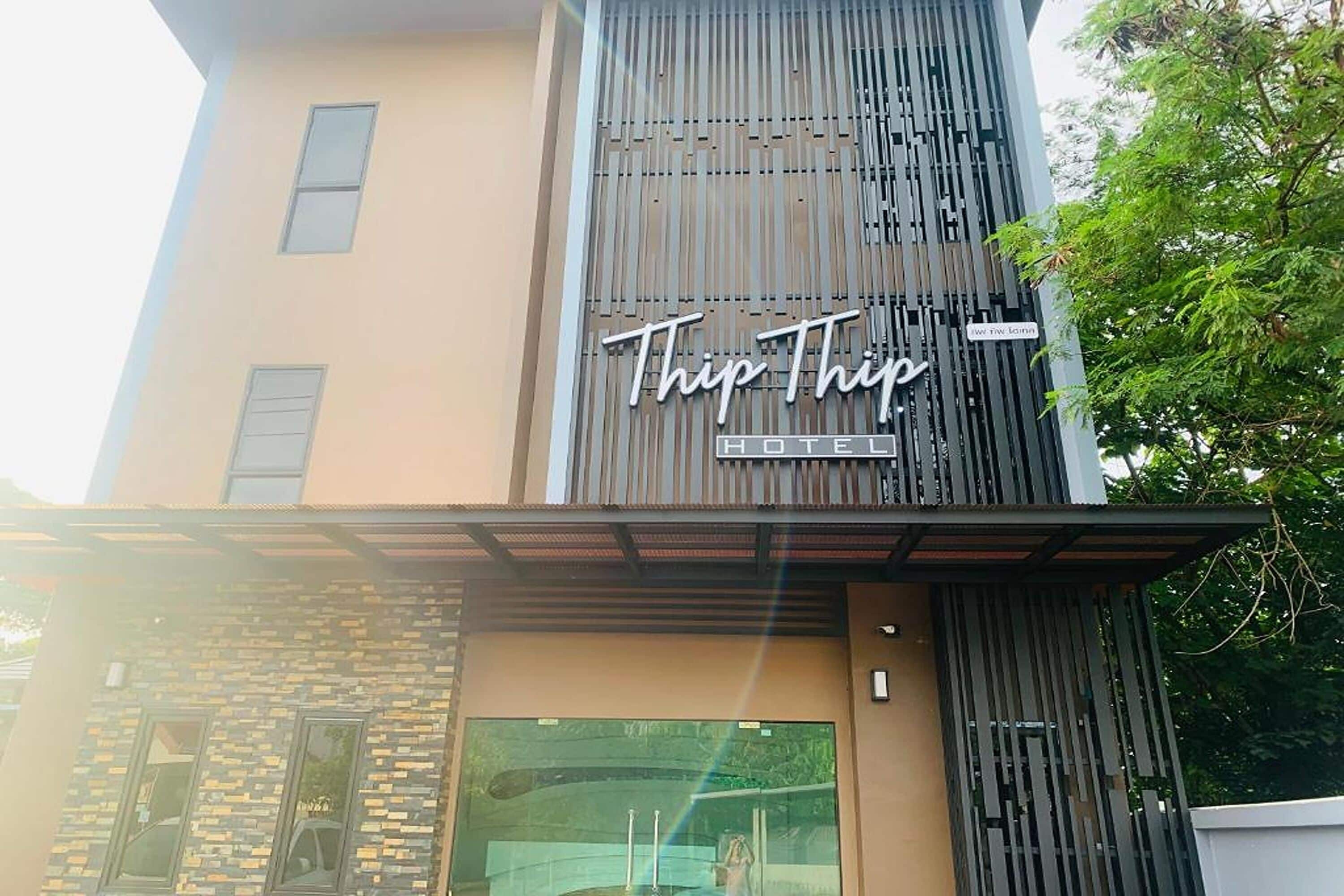 A modern hotel named "TripTrip" with a prominent sign on the facade.