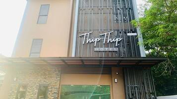 A modern hotel named "TripTrip" with a prominent sign on the facade.