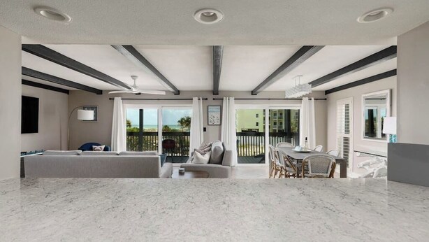 A modern interior with a kitchen, dining area, and a balcony with a view.