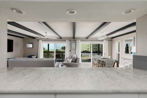 A modern interior with a kitchen, dining area, and a balcony with a view.