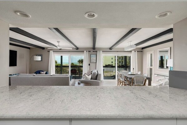 A modern interior with a kitchen, dining area, and a balcony with a view.