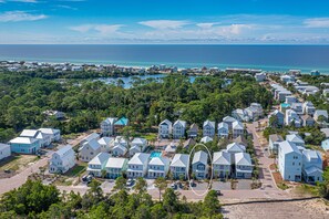 Luchtbeeld van een kustbewoonde wijk met huizen, een zwembad en uitzicht op de oceaan.