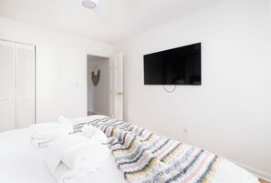 Un dormitorio con una cama, televisión y armario.