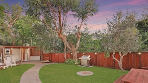 A backyard with a wooden deck, a barbecue grill, and a picnic table. - Beautiful ground floor unit in Central Point Lookout (Point Lookout)