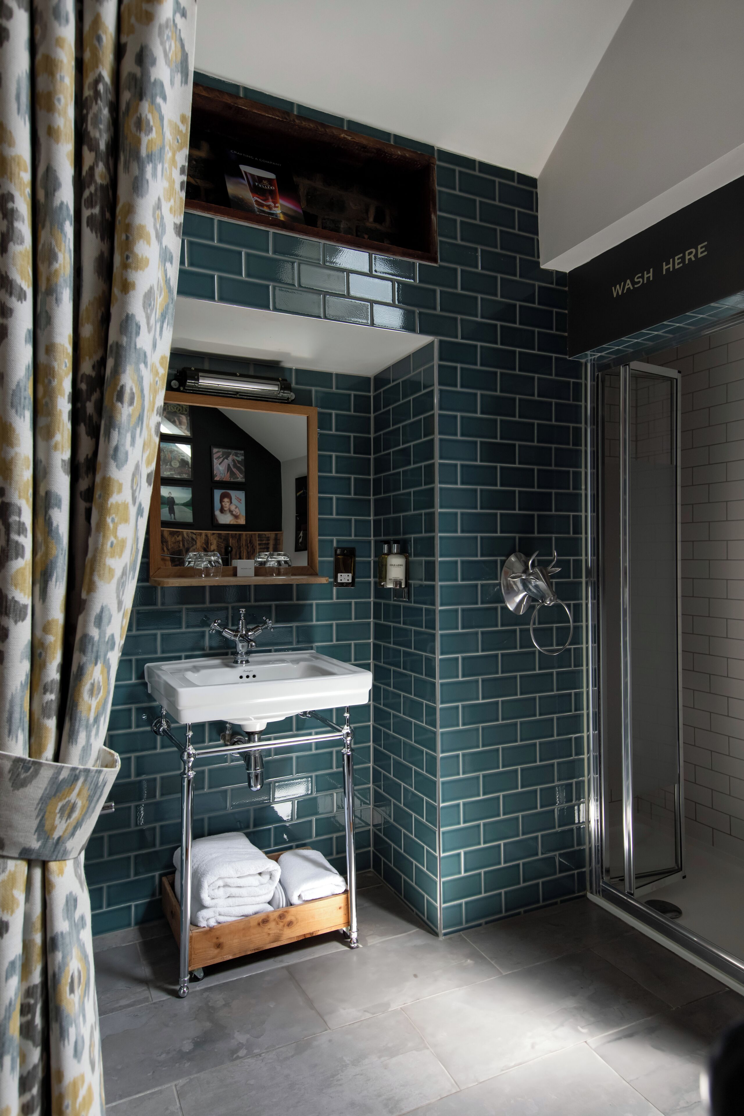 A bathroom with a white sink, a mirror, and a shower area.