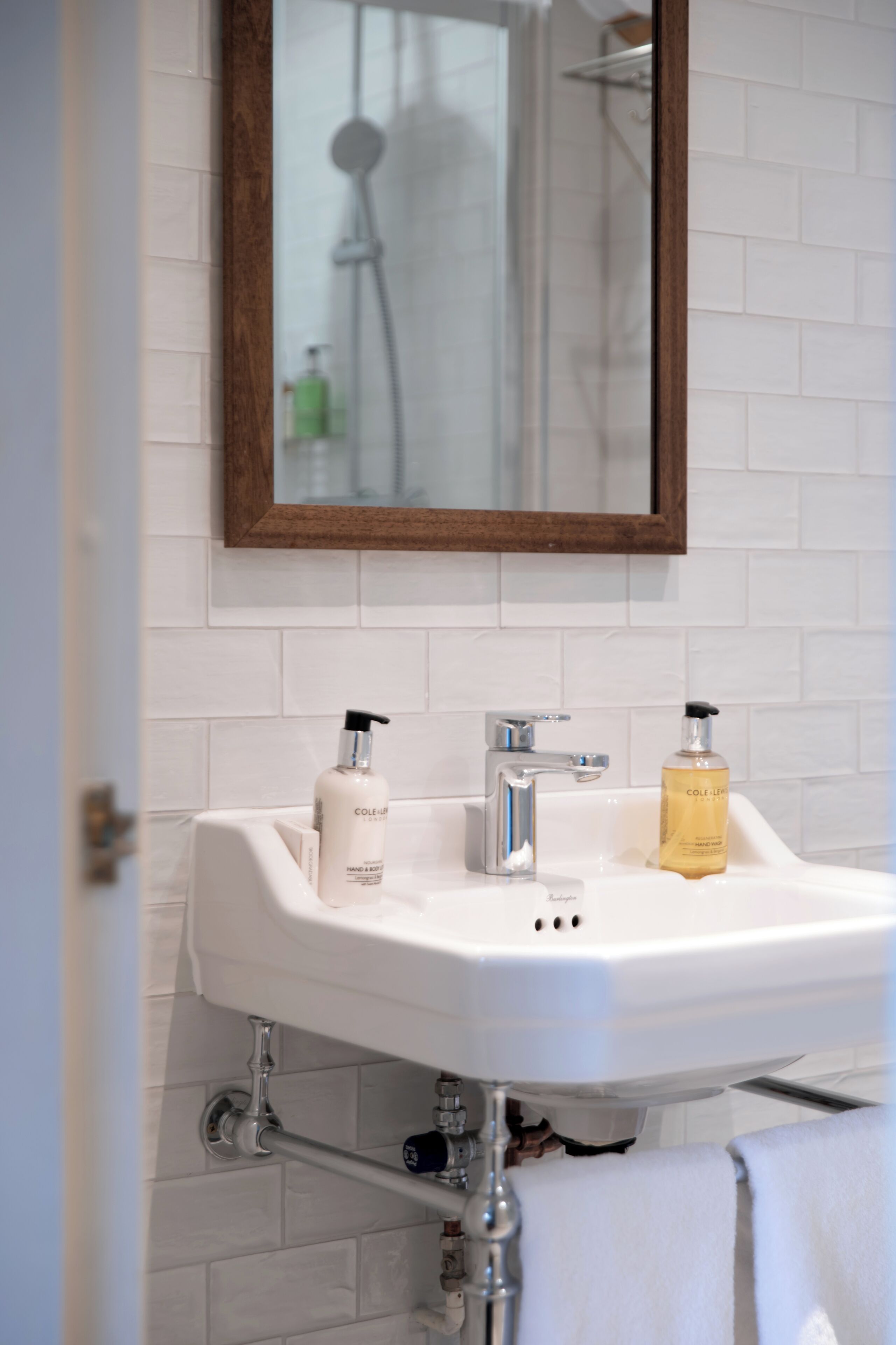 A bathroom with a white sink, two bottles of hand soap, and a mirror above the sink.