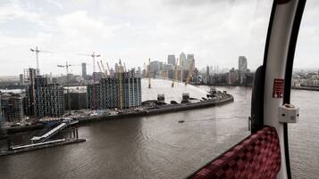 Vista de un río con un puente y grúas de construcción al fondo.