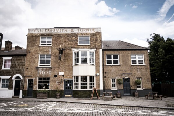 A traditional brick building with a sign reading "FULLER SMITH & TURNER" and a smaller sign "The Pilot" below it.