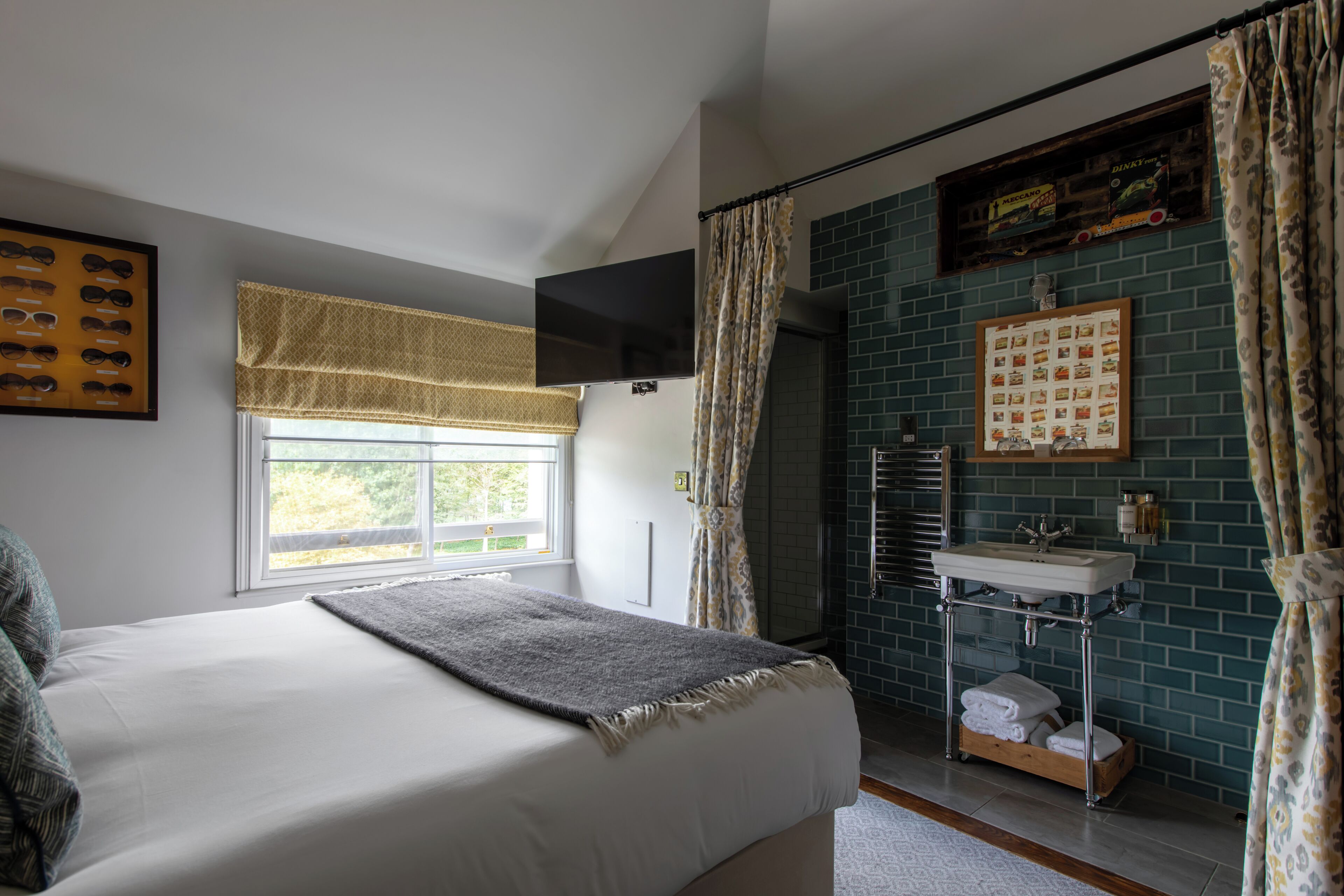 Une chambre avec un lit, une fenêtre donnant sur un beau paysage, une salle de bain avec un lavabo et une douche.