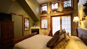 A bedroom with a large bed, a fireplace, a television, and a window with curtains. - WeatherPine Inn (Niagara-on-the-Lake)