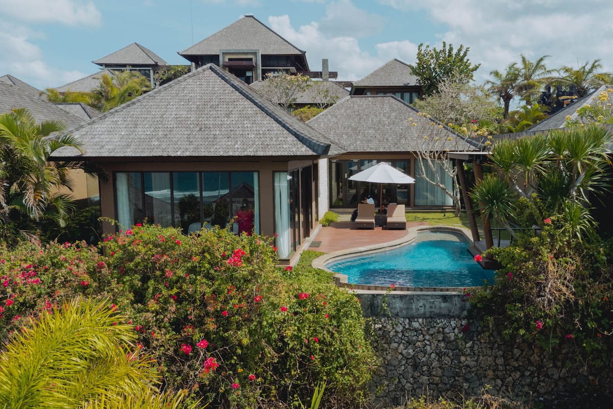 Ein Resort mit mehreren Gebäuden, einem Schwimmbad und üppiger Vegetation.