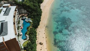 Vue aérienne d’un complexe hôtelier doté d’une piscine, d’une plage et donnant sur l’océan.