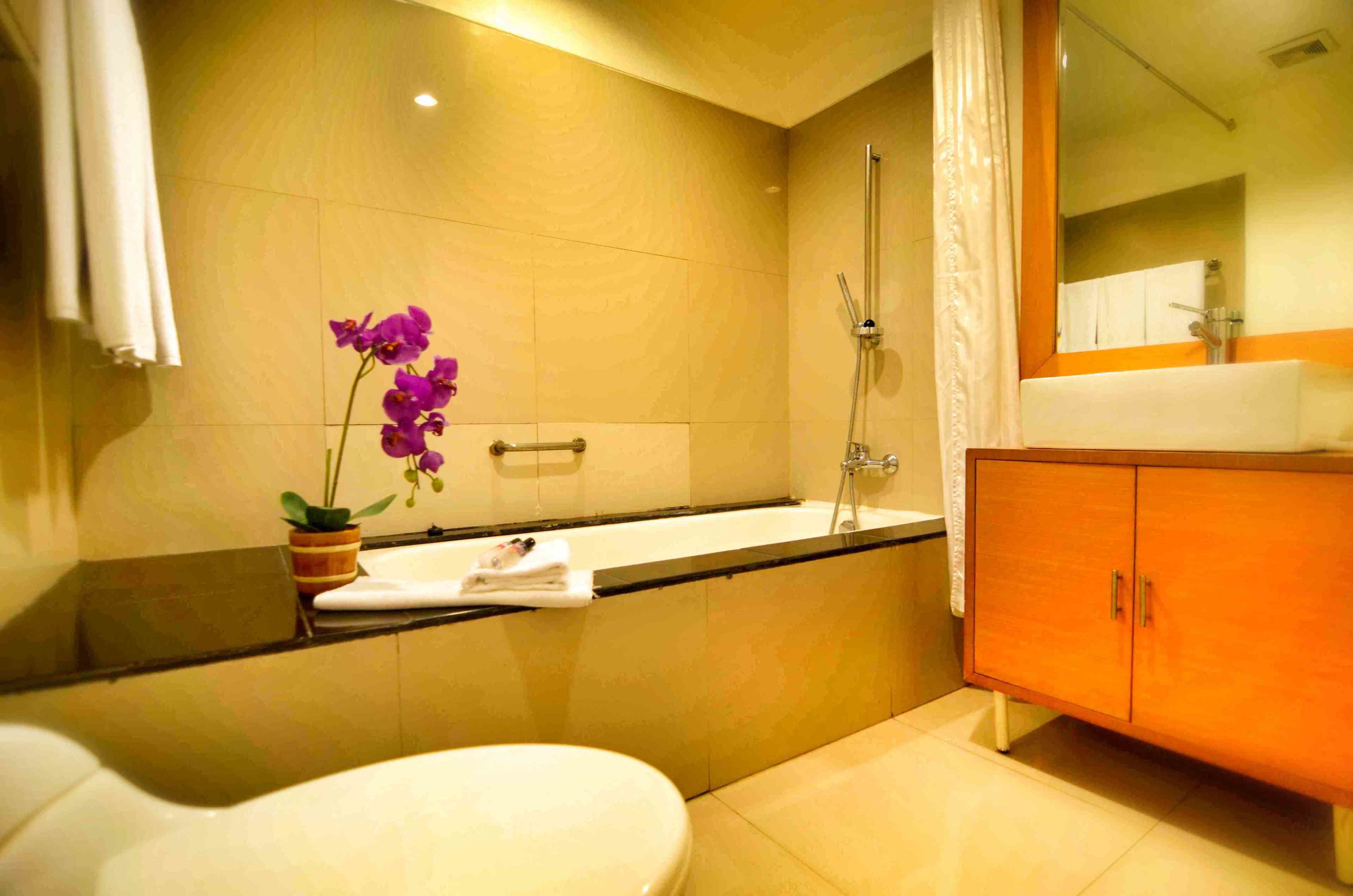 A bathroom with a toilet, sink, bathtub, and a cabinet.