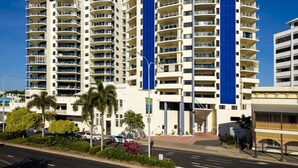 A modern high-rise building with multiple balconies and a prominent blue vertical feature. - Jack & Newell Holiday Apartments (Cairns)