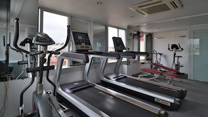 A gym with treadmills, a stationary bike, and a bench press.