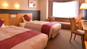 A hotel room with two beds, a desk with a TV, a chair, and a window with curtains. - Sapporo Classe Hotel (Sapporo)
